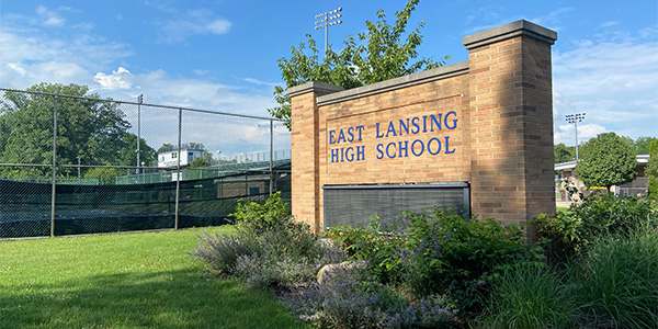 Tennis courts near "East Lansing High School" sign.