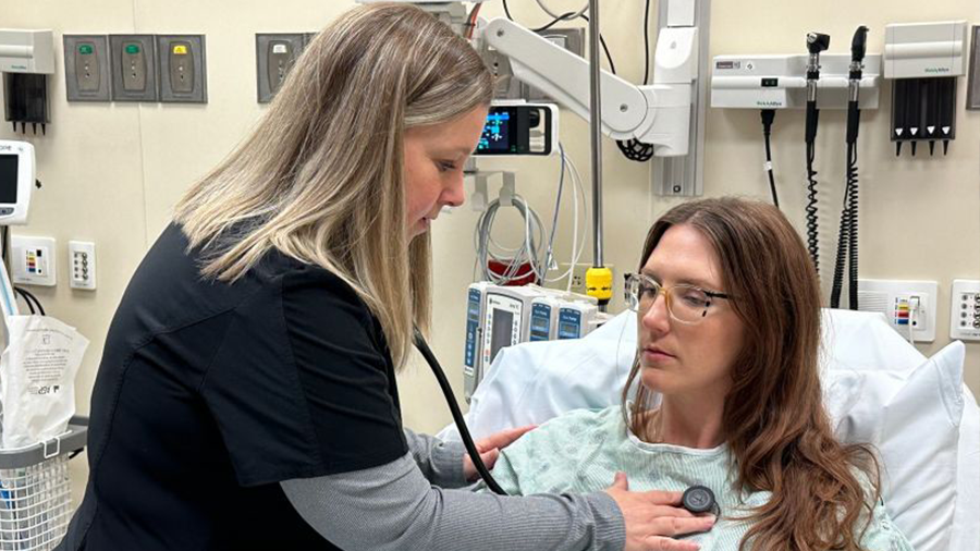 Mindy checking a patient's breathing in the ER.