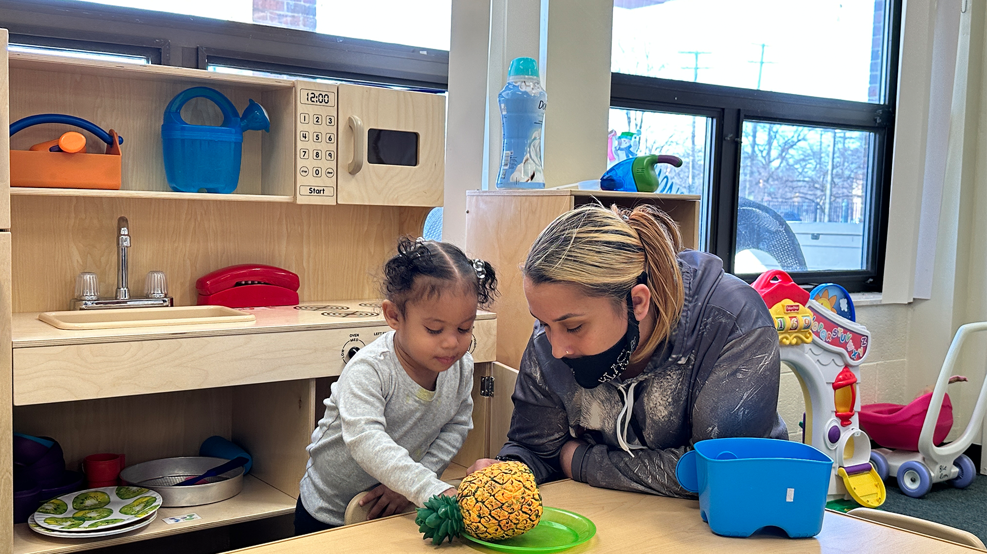 Miracle and mother, Marcella, in play kitchen.